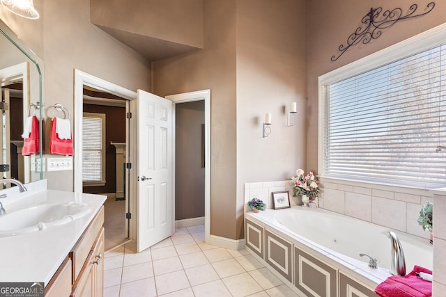 bathroom with a bathing tub, vanity, and tile patterned flooring