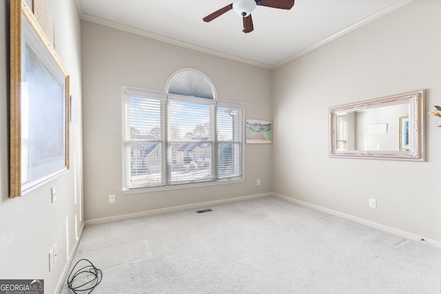 empty room featuring ceiling fan, light colored carpet, and crown molding