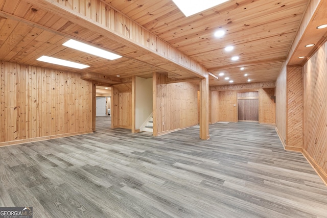 basement featuring hardwood / wood-style flooring, wooden walls, and wood ceiling