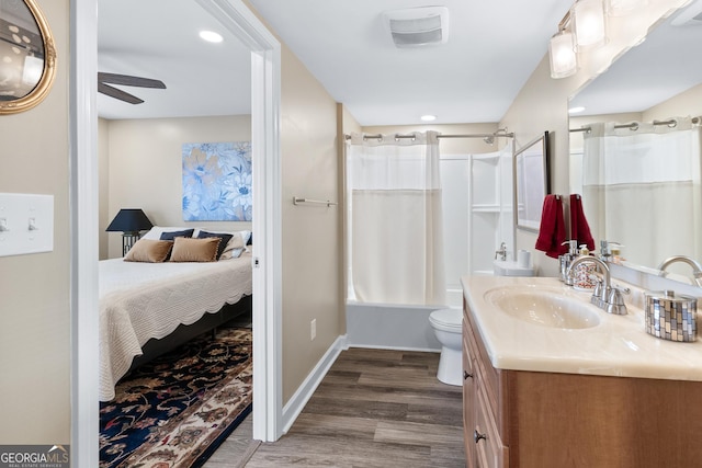 full bathroom featuring ceiling fan, hardwood / wood-style floors, toilet, shower / tub combo with curtain, and vanity