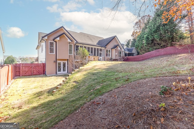 back of house with french doors, a yard, and a sunroom