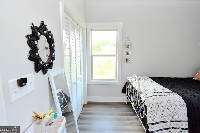 bedroom with multiple windows and hardwood / wood-style flooring