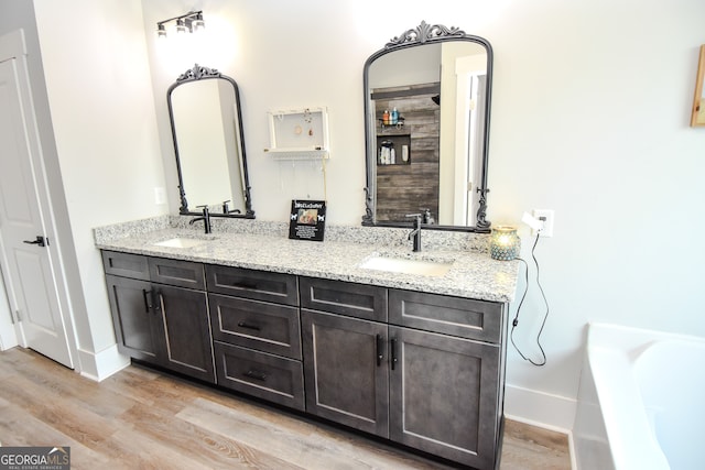 bathroom with vanity, a bathing tub, and hardwood / wood-style flooring