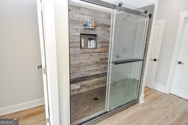 bathroom with wood-type flooring and an enclosed shower