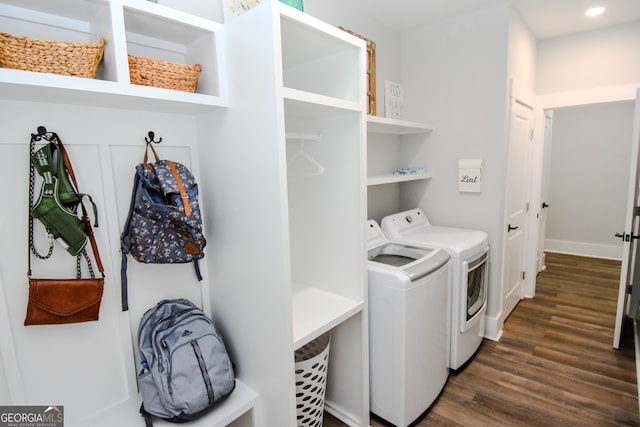 clothes washing area featuring washing machine and clothes dryer and dark hardwood / wood-style floors