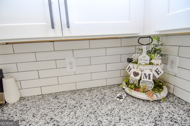 details with light stone countertops and white cabinetry