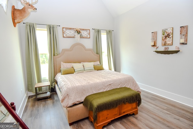 bedroom featuring high vaulted ceiling and dark hardwood / wood-style floors