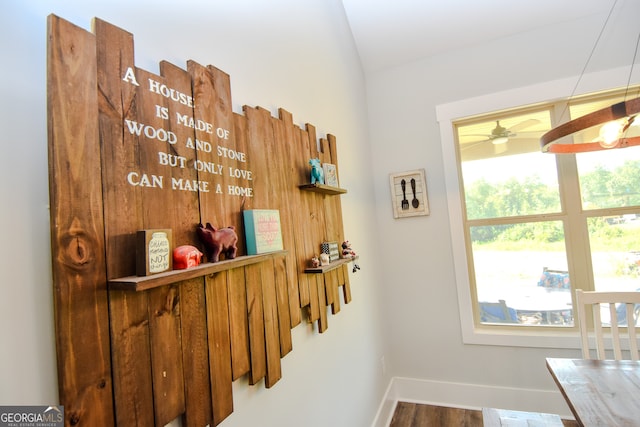 corridor with a wealth of natural light and hardwood / wood-style floors