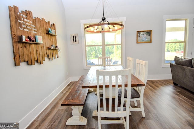 dining room with a wealth of natural light, dark hardwood / wood-style flooring, and a notable chandelier