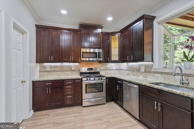 kitchen with a wealth of natural light, backsplash, stainless steel appliances, and sink