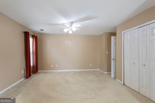 unfurnished bedroom with light colored carpet and ceiling fan