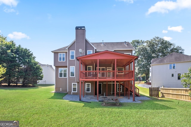 back of property with a lawn and a deck