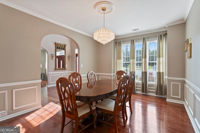 dining area featuring crown molding, a chandelier, and dark hardwood / wood-style flooring