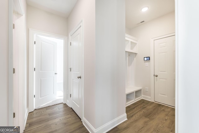 mudroom with wood finished floors, visible vents, and baseboards