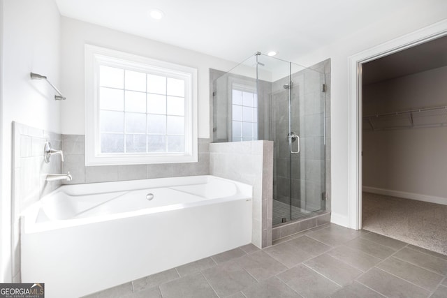 bathroom featuring recessed lighting, a spacious closet, a stall shower, a bath, and tile patterned floors