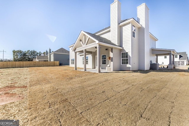 back of house featuring a ceiling fan, a chimney, fence, a patio area, and central AC