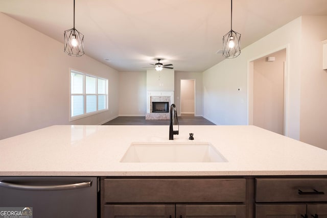 kitchen with hardwood / wood-style floors, sink, stainless steel dishwasher, ceiling fan, and light stone countertops