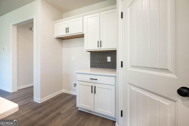 kitchen with backsplash, white cabinetry, and dark wood-type flooring