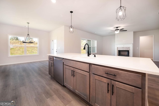 kitchen with ceiling fan, sink, dark hardwood / wood-style flooring, stainless steel dishwasher, and pendant lighting