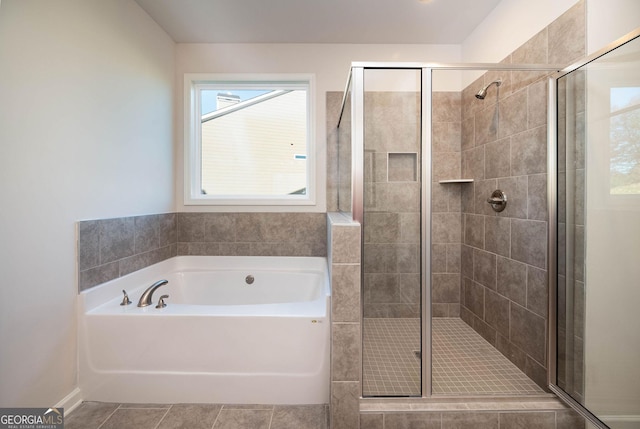 bathroom with tile patterned floors and shower with separate bathtub