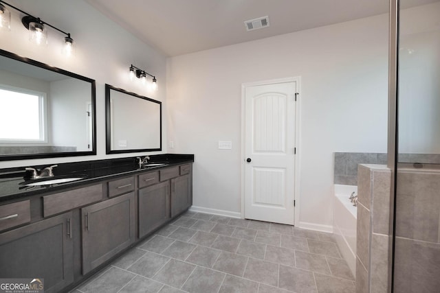 bathroom with tile patterned flooring, vanity, and a bathing tub