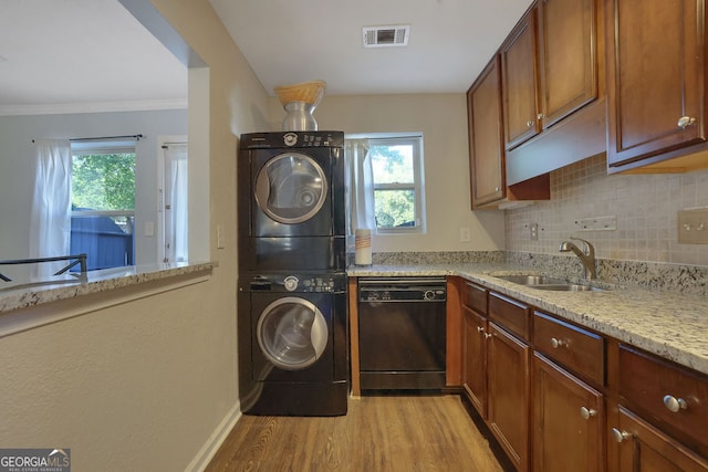 laundry room featuring ornamental molding, light hardwood / wood-style floors, stacked washer / drying machine, and sink