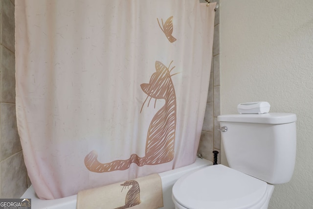 bathroom featuring toilet and shower / bath combination with curtain