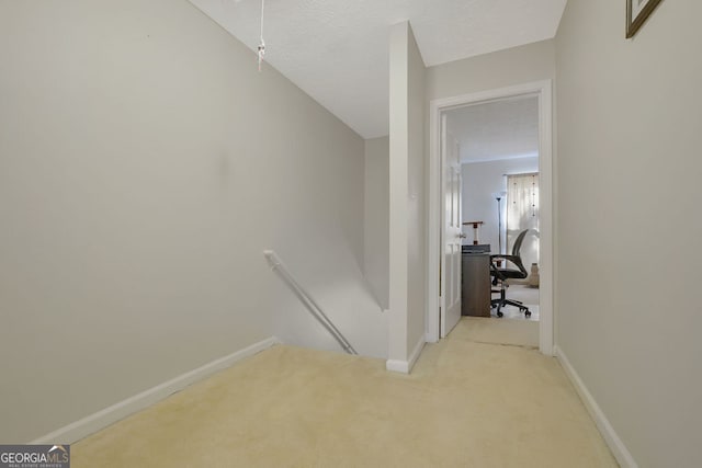 corridor featuring light colored carpet, a textured ceiling, and lofted ceiling