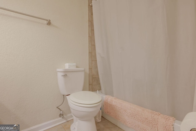 bathroom with a shower with shower curtain, tile patterned floors, and toilet