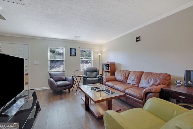 living room featuring a textured ceiling, ornamental molding, and dark hardwood / wood-style floors