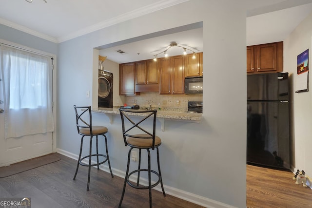 kitchen with decorative backsplash, a breakfast bar, kitchen peninsula, black appliances, and wood-type flooring