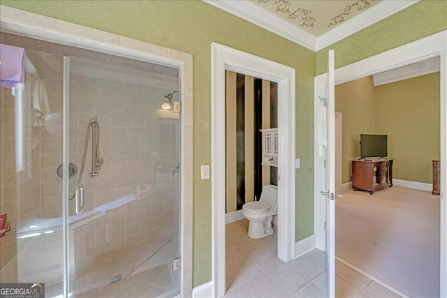 bathroom featuring a shower with door, crown molding, toilet, and tile patterned flooring