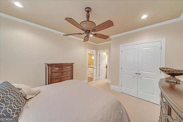 carpeted bedroom with ornamental molding, ceiling fan, and a closet