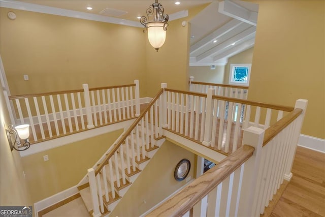 staircase featuring wood-type flooring, an inviting chandelier, and vaulted ceiling