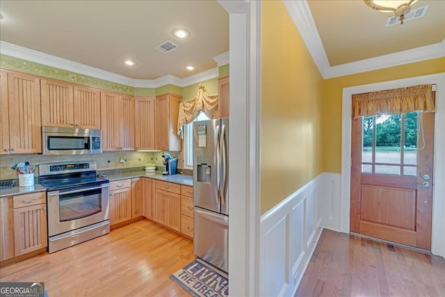 kitchen with decorative backsplash, stainless steel appliances, light hardwood / wood-style floors, and ornamental molding