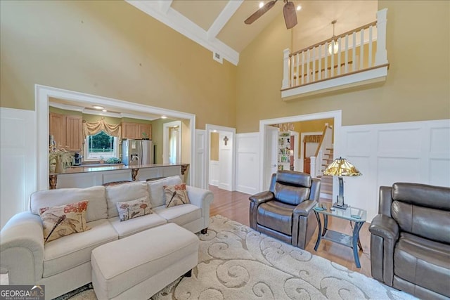 living room with high vaulted ceiling, ceiling fan, beamed ceiling, and wood-type flooring