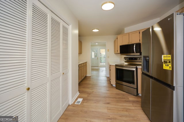 kitchen with light wood-type flooring, appliances with stainless steel finishes, and light brown cabinetry