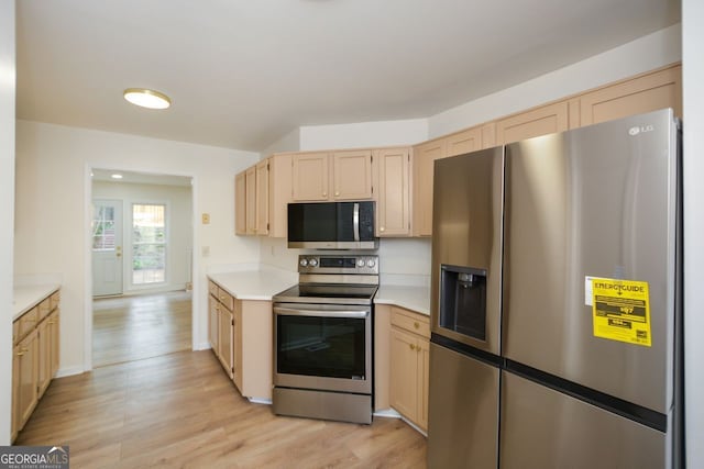 kitchen with light brown cabinetry, light hardwood / wood-style flooring, and stainless steel appliances