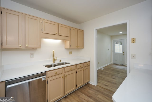 kitchen featuring light wood-type flooring, light brown cabinets, stainless steel dishwasher, and sink