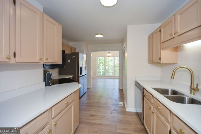 kitchen featuring dishwasher, light brown cabinetry, sink, and light hardwood / wood-style floors