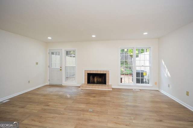 unfurnished living room featuring a fireplace and light hardwood / wood-style flooring