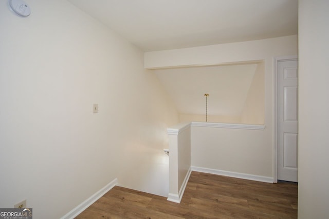 corridor with lofted ceiling and dark hardwood / wood-style flooring