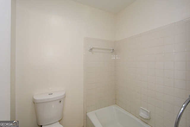 bathroom with toilet and tiled shower / bath combo