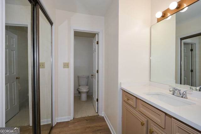 bathroom featuring vanity, toilet, and wood-type flooring