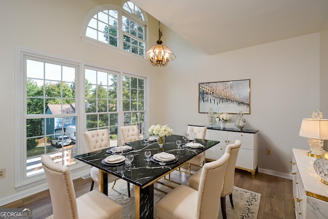 dining space featuring an inviting chandelier, a healthy amount of sunlight, and wood-type flooring