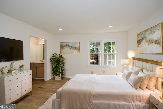 bedroom featuring sink, ensuite bathroom, and light hardwood / wood-style flooring