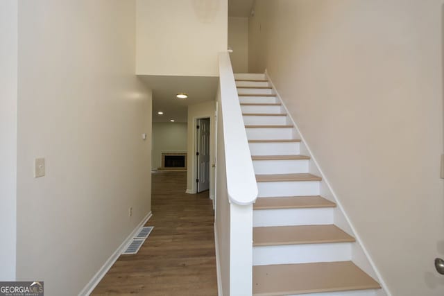 staircase with hardwood / wood-style floors