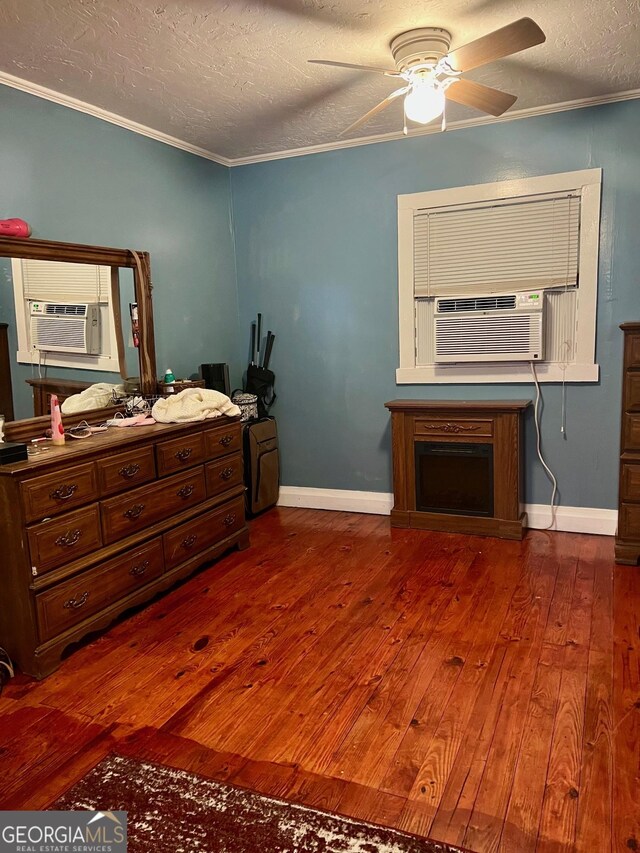 bedroom featuring a textured ceiling, dark hardwood / wood-style floors, cooling unit, ornamental molding, and ceiling fan