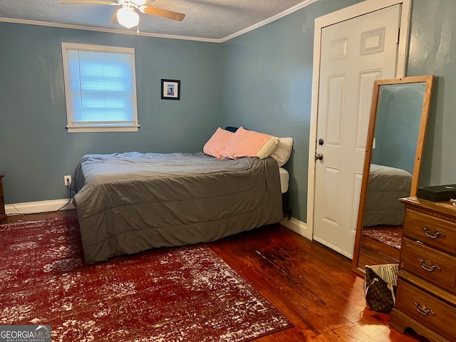 bedroom with ornamental molding, ceiling fan, dark hardwood / wood-style floors, and a textured ceiling