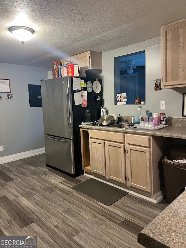 kitchen with baseboards, dark wood-style floors, freestanding refrigerator, a textured ceiling, and light brown cabinetry